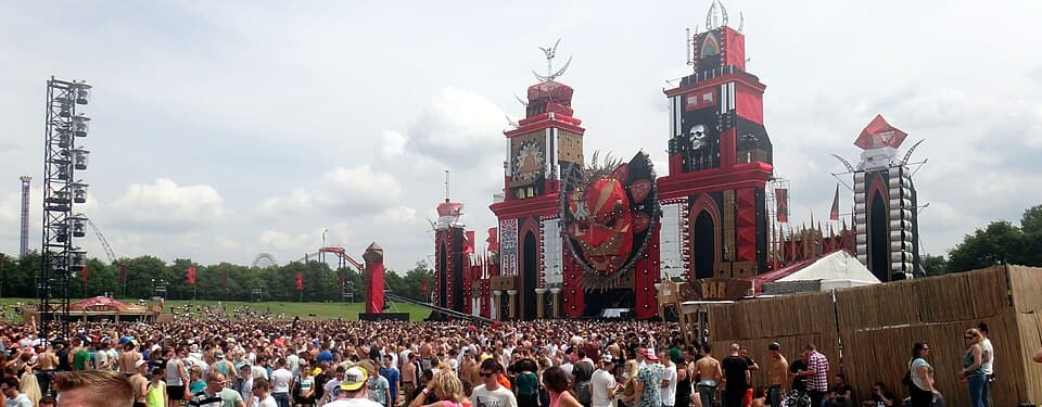 A crowd in front of the red, tower-shaped main stage at the Defqon.1 festival in Biddinghuizen, Netherlands, by day in 2014.